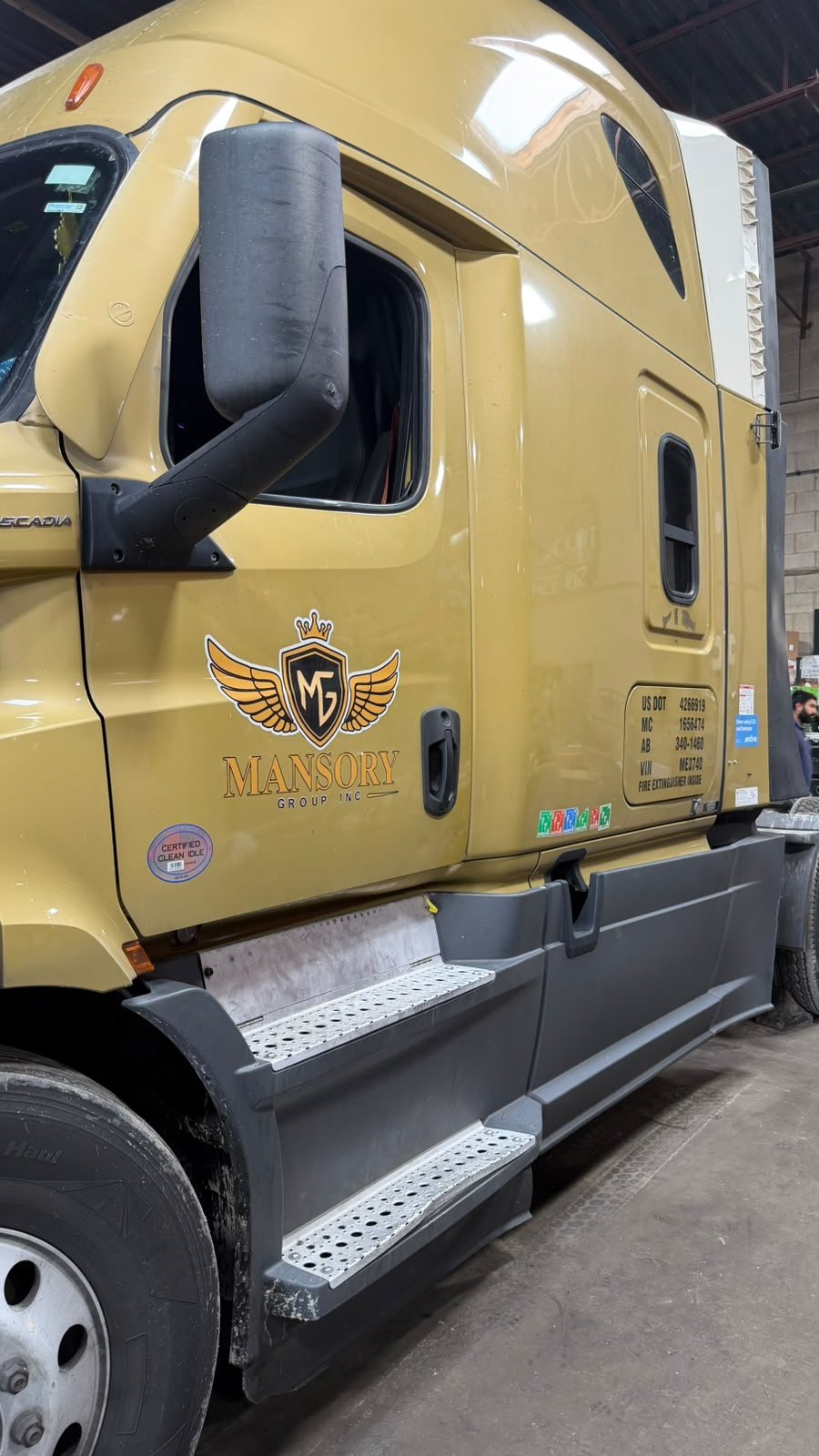 Gold Mansory Group cab door with the company logo and USDOT and MC numbers lettered on it